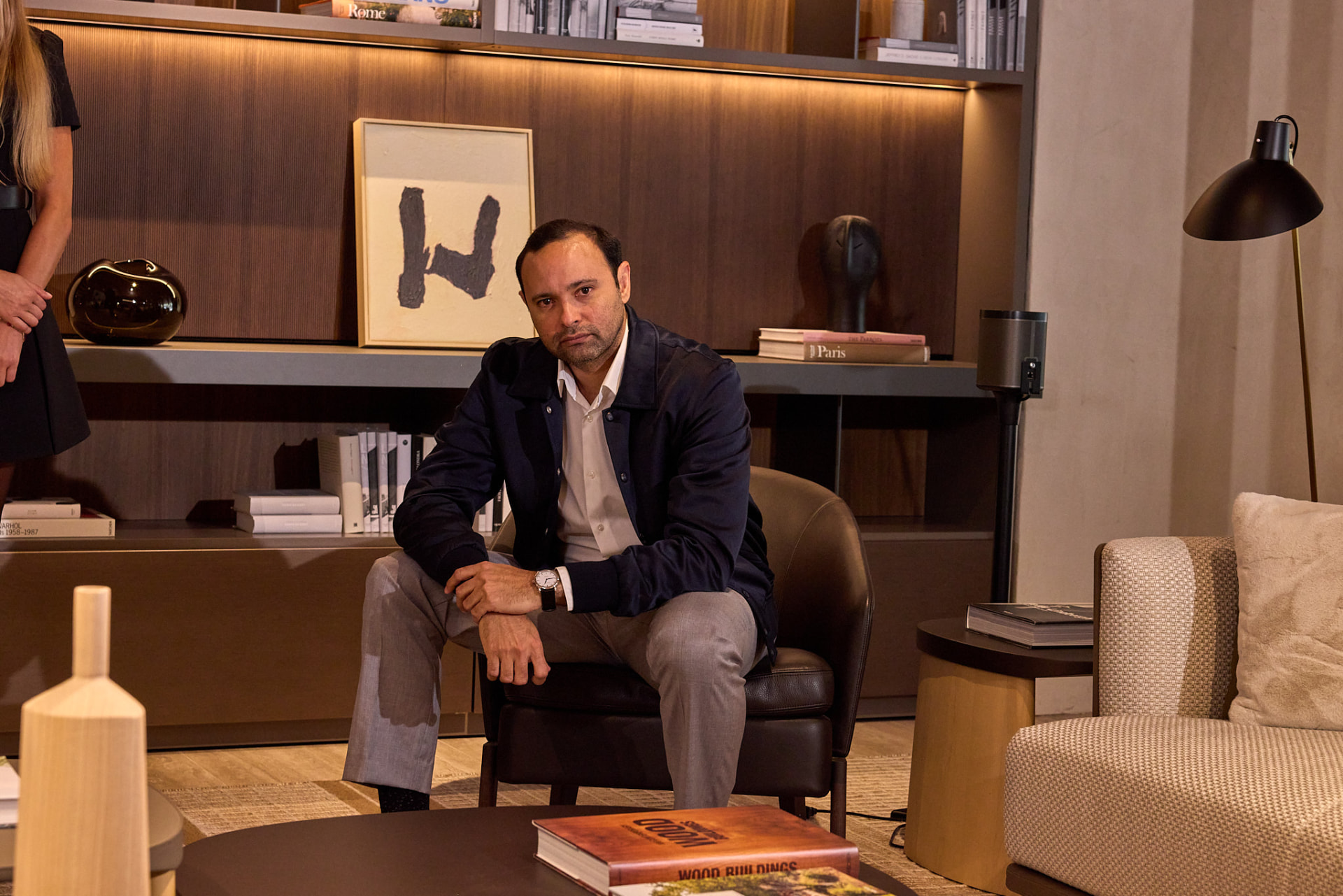Retrato de José Hernández en un entorno de biblioteca y mobiliario de diseño